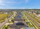 High-angle view of a neighborhood with modern homes, solar panels, green lawns, and community amenities under a clear sky at 4201 Globe Thistle Dr, Tampa, FL 33619