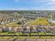 Aerial view of a planned community featuring single-Gathering homes, green spaces, playground and pool with solar panels on roofs at 4201 Globe Thistle Dr, Tampa, FL 33619