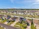 Panoramic aerial shot of a housing development, featuring well-kept lawns, solar panels, and contemporary homes under a bright sky at 4201 Globe Thistle Dr, Tampa, FL 33619