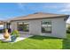 Backyard view featuring a well-maintained lawn and a simple patio area with stylish plant decorations at 4201 Globe Thistle Dr, Tampa, FL 33619