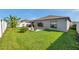 Spacious backyard featuring a manicured lawn, patio, and grey stucco walls at 4201 Globe Thistle Dr, Tampa, FL 33619