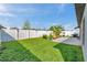 Spacious backyard with green grass, white fence, and a patio area perfect for entertaining at 4201 Globe Thistle Dr, Tampa, FL 33619