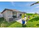 Exterior view of the backyard featuring a patio, lush green lawn, privacy fence, and tropical foliage at 4201 Globe Thistle Dr, Tampa, FL 33619