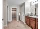 Bathroom featuring double sinks, tiled floor, and a spacious walk-in closet with ample storage at 4201 Globe Thistle Dr, Tampa, FL 33619
