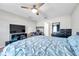 Comfortable bedroom featuring a TV, desk, dresser, and blue bedding, designed for relaxation at 4201 Globe Thistle Dr, Tampa, FL 33619