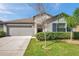 Charming single-story home featuring a well-manicured lawn and an attached two-car garage at 4201 Globe Thistle Dr, Tampa, FL 33619