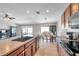 A modern kitchen island looks into the dining room, featuring seating and dark wood cabinets at 4201 Globe Thistle Dr, Tampa, FL 33619
