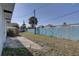 Side yard featuring a concrete path and blue privacy fence under a clear blue sky at 440 S Bayshore Dr, Madeira Beach, FL 33708