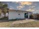 A detached structure in the backyard with a concrete slab patio, door, and sliding glass door at 440 S Bayshore Dr, Madeira Beach, FL 33708