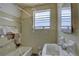 Damaged bathroom with a window, bathtub and single sink at 440 S Bayshore Dr, Madeira Beach, FL 33708