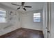 Bedroom features two windows, damaged walls, ceiling fan, and bare floors at 440 S Bayshore Dr, Madeira Beach, FL 33708