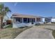 Charming single-story home with a screened porch and well-lit exterior, surrounded by a lush lawn and mature trees at 440 S Bayshore Dr, Madeira Beach, FL 33708