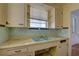 Damaged kitchen sink and countertop with window and cabinets above at 440 S Bayshore Dr, Madeira Beach, FL 33708