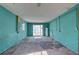 Empty room with aqua-painted walls, sliding glass doors, and concrete floor at 440 S Bayshore Dr, Madeira Beach, FL 33708