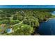 Aerial view of the community with lake access, a pier, and green spaces, providing recreational opportunities at 4693 Aylesford Dr, Palm Harbor, FL 34685