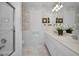 Bright bathroom featuring a double vanity, marble countertops, white cabinets, and a glass shower door at 4693 Aylesford Dr, Palm Harbor, FL 34685