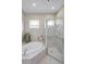 Bathroom featuring a soaking tub, a glass shower with tile walls, and two windows at 4693 Aylesford Dr, Palm Harbor, FL 34685