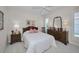 Bedroom featuring a dresser, two end tables, a ceiling fan, and a large window at 4693 Aylesford Dr, Palm Harbor, FL 34685