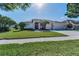 Charming single-story home with manicured lawn and landscaping, featuring a 3 car garage at 4693 Aylesford Dr, Palm Harbor, FL 34685