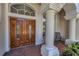 Close-up of the home's grand double doors with decorative glass and sidelight windows at 4693 Aylesford Dr, Palm Harbor, FL 34685