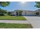 Inviting single-story home featuring a manicured lawn and an elegant double-door entrance at 4693 Aylesford Dr, Palm Harbor, FL 34685