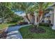 Beautiful home with palm trees and landscaped walkway leading to the front entrance at 4693 Aylesford Dr, Palm Harbor, FL 34685