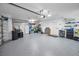 Large garage with epoxy flooring, overhead lighting, shelving, and plenty of storage space for cars and other belongings at 4693 Aylesford Dr, Palm Harbor, FL 34685