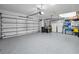 Well-lit garage showcasing epoxy floors, multiple storage areas, and space for multiple vehicles at 4693 Aylesford Dr, Palm Harbor, FL 34685