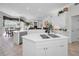 Open kitchen with white cabinets, a center island, stainless steel appliances, and a view into the living area at 4693 Aylesford Dr, Palm Harbor, FL 34685