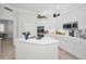 Bright kitchen featuring white cabinets, an island with a cooktop, stainless steel appliances, and decor at 4693 Aylesford Dr, Palm Harbor, FL 34685