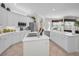 Well-lit kitchen with white cabinets, stainless steel appliances, decor and a view into the dining area at 4693 Aylesford Dr, Palm Harbor, FL 34685