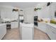 Bright kitchen with white cabinets, a center island with a cooktop, stainless steel appliances, and decor at 4693 Aylesford Dr, Palm Harbor, FL 34685