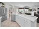 Open kitchen with white cabinets, stainless steel appliances, and an island with a sink and views of the living area at 4693 Aylesford Dr, Palm Harbor, FL 34685