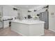Bright kitchen with white cabinets, a large island, stainless steel appliances, and modern fixtures at 4693 Aylesford Dr, Palm Harbor, FL 34685
