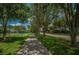 Scenic neighborhood walking path lined with mature trees and lush green grass for outdoor recreation at 4693 Aylesford Dr, Palm Harbor, FL 34685