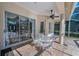 Covered patio featuring a round table, white chairs, and views of the lush backyard at 4693 Aylesford Dr, Palm Harbor, FL 34685
