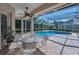 Enclosed pool area with outdoor seating and lush greenery providing privacy at 4693 Aylesford Dr, Palm Harbor, FL 34685