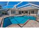 An exterior shot of a screened pool with brick pavers and the back of the home in the background at 4693 Aylesford Dr, Palm Harbor, FL 34685