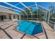 Screened in pool with view of manicured lawn and privacy hedges at 4693 Aylesford Dr, Palm Harbor, FL 34685