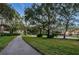 Paved walking path winding through a lush, green community with mature trees at 4693 Aylesford Dr, Palm Harbor, FL 34685