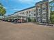 Attractive condominium building featuring balconies, stone accents, and covered parking at 4801 Airport Rd # 118, Zephyrhills, FL 33542