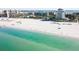 A scenic beach with clear turquoise waters meeting a sandy shore, backed by beachfront buildings and clear skies at 500 45Th S St, St Petersburg, FL 33711