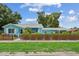 Charming light-blue home with a well-maintained lawn and decorative brown picket fence enhancing the curb appeal at 500 45Th S St, St Petersburg, FL 33711