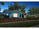 Charming blue home with a well-manicured lawn, picket fence, and inviting front porch at 500 45Th S St, St Petersburg, FL 33711