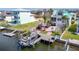 Aerial view of backyard featuring a boat lift, tiki bar, swimming pool and manicured lawn at 5623 Jobeth Dr, New Port Richey, FL 34652