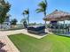 Backyard with a tiki bar, hot tub, lush landscaping, and a pool, creating a luxurious outdoor living space at 5623 Jobeth Dr, New Port Richey, FL 34652