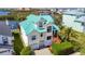 Stunning waterfront home with a vibrant teal roof and charming curb appeal in a desirable coastal community at 5623 Jobeth Dr, New Port Richey, FL 34652