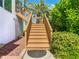 Outdoor staircase with wooden steps leading to a raised entry with green landscape at 5623 Jobeth Dr, New Port Richey, FL 34652