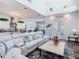 Bright living room features a high ceiling and sliding glass doors with beach-themed decorations and furnishings at 5623 Jobeth Dr, New Port Richey, FL 34652