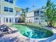 Beautiful pool area with lounge chairs, surrounded by lush tropical landscaping and a well manicured lawn at 5623 Jobeth Dr, New Port Richey, FL 34652